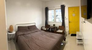 a bedroom with a bed and a yellow door at Homestay Laksi in Lak Si