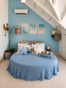 a blue bedroom with a large bed with blue walls at Deja Blue - Comfortable Beachfront condo in Marigot