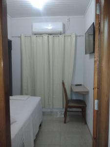 a bedroom with a bed and a chair and a window at Hotel New in Formosa
