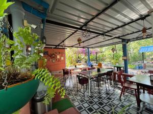 a restaurant with tables and chairs and plants at Wilderness Jungle Camp in Malavalli