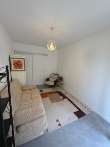 a living room with a couch and a chair at Studio en maison historique in Golfe-Juan