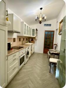 a large kitchen with white cabinets and a table at Studio en maison historique in Golfe-Juan