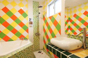 Baño colorido con bañera y lavamanos en Ocean Star B&B en Kenting