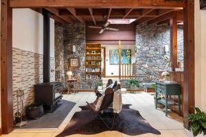 a living room with a stone wall and a stove at Banyula in Bawley in Bawley Point
