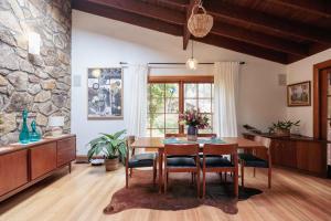 a dining room with a table and chairs and a stone wall at Banyula in Bawley in Bawley Point +20 photos