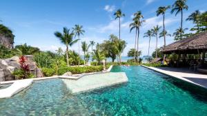 a swimming pool at a resort with palm trees at TreeHouse Villas Koh Yao - Adults Only in Ko Yao Noi +27 photos