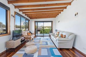 a living room with a couch and a tv at Barker Retreat in Burrill Lake