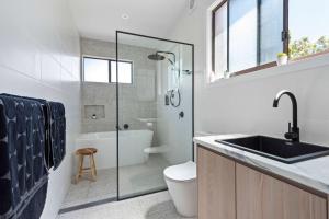 a bathroom with a sink and a toilet and a shower at Barker Retreat in Burrill Lake