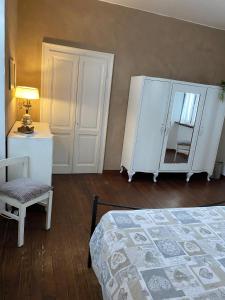 a bedroom with a bed and a chair and a mirror at Casa Clem centro Menaggio con possibilità di garage in Menaggio
