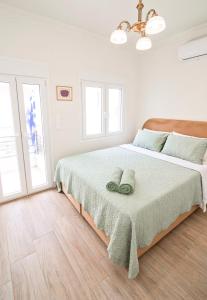 a white bedroom with a large bed with a wooden headboard at Villa St George in Kalymnos