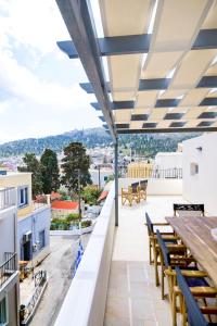 a balcony with tables and chairs and a view of the city at Villa St George in Kalymnos