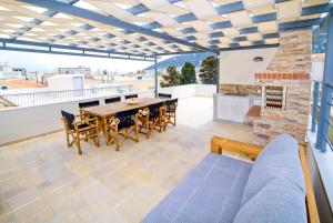 a patio with a table and chairs on a roof at Villa St George in Kalymnos