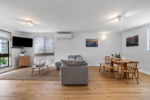 a living room with a couch and a table at Lilly Pilly at Callala Beach in Callala Beach