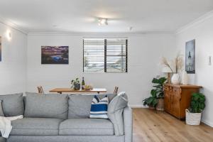 a living room with a couch and a table at Lilly Pilly at Callala Beach in Callala Beach +28 photos
