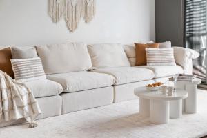 a white living room with a white couch and tables at Sanctuary Splash Getaway in Sanctuary Point