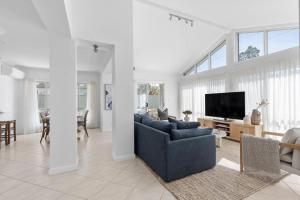a living room with a blue couch and a tv at Husky Salt in Huskisson