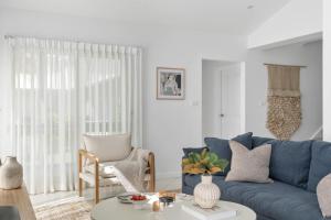 a living room with a blue couch and a table at Husky Salt in Huskisson