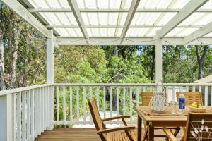 a white pergola on a deck with a table and chairs at Kangaroo Sanctuary in Sanctuary Point
