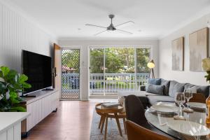 a living room with a couch and a tv and a table at Kangaroo Sanctuary in Sanctuary Point