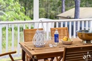 a wooden table with a bottle of water and a bowl of fruit at Kangaroo Sanctuary in Sanctuary Point