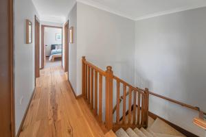 a hallway with a wooden staircase with a stair case at Sea Stroll at Callala Beach in Callala Beach