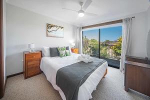 a bedroom with a bed and a large window at Sea Stroll at Callala Beach in Callala Beach +10 photos