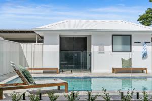 a house with a swimming pool in front of it at Beachside on Beecroft in Huskisson