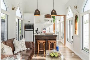 a living room with a couch and a kitchen at Chapel by the Bay in Erowal Bay