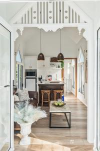 a living room with a table and a kitchen at Chapel by the Bay in Erowal Bay +29 photos