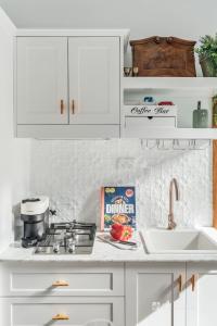 a kitchen counter with white cabinets and a sink at Chapel by the Bay in Erowal Bay