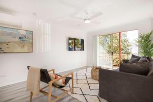 a living room with a couch and a chair at Aquamarine - modern & bright Huskisson townhouse in Huskisson