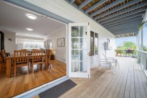 a dining room and living room with a sliding glass door at Bowen View - pet-friendly home near Hyams Beach in Hyams Beach +14 photos