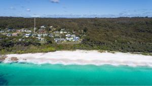 an aerial view of a beach with houses and the ocean at Footprints at Hyams Beach - 4BR home w. games room in Hyams Beach