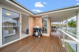 a home with a balcony with a stroller on the deck at Footprints at Hyams Beach - 4BR home w. games room in Hyams Beach