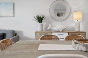 a dining room table with chairs and a mirror at Days By The Bay - 3BR house with ocean views in Hyams Beach