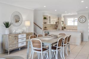 a kitchen and dining room with a table and chairs at Days By The Bay - 3BR house with ocean views in Hyams Beach