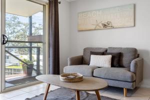 a living room with a couch and a table at Days By The Bay - 3BR house with ocean views in Hyams Beach
