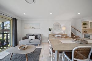 a living room with a table and chairs at Days By The Bay - 3BR house with ocean views in Hyams Beach +25 photos