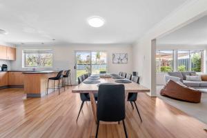 a dining room and kitchen with a table and chairs at Amalena by the sea - Vincentia 5BR home with pool in Vincentia +17 photos