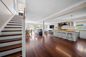a kitchen and living room with a staircase in a house at Karinya Jervis Bay - 4BR home & optional studio in Vincentia