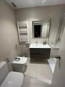 a bathroom with a sink and a toilet and a mirror at Casa Flores in El Campello