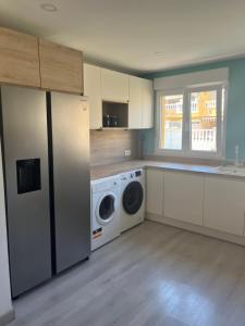 a kitchen with a refrigerator and a washing machine at Casa Flores in El Campello