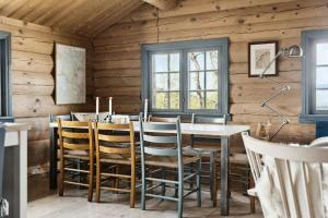 a dining room with wooden walls and a table and chairs at Traditional Log Cabin At Vierli in Rauland