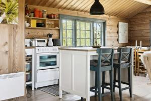 a kitchen with a white island with stools at Traditional Log Cabin At Vierli in Rauland