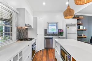 a kitchen with white cabinets and a white counter top at The Shack - Myola in Myola