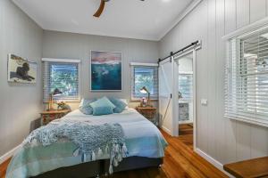 a bedroom with a bed and two lamps and windows at The Shack - Myola in Myola +11 photos