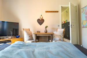 a bedroom with a table and a tv and a bed at Hyggeligt værelse med lækkert badeværelse in Horsens