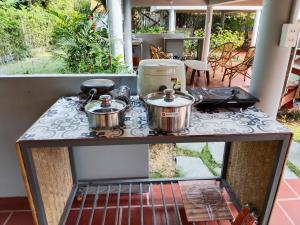 a stove top with pots and pans on it at Forest Home Phu Quoc is located beside the forest and on a hillside in Phú Quốc +54 photos