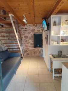 a room with a couch and a table and a tv at Krka Waterfalls Stonehouse Roko in Lozovac