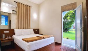 a bedroom with a bed and a large window at SUSAGADE in Vagator